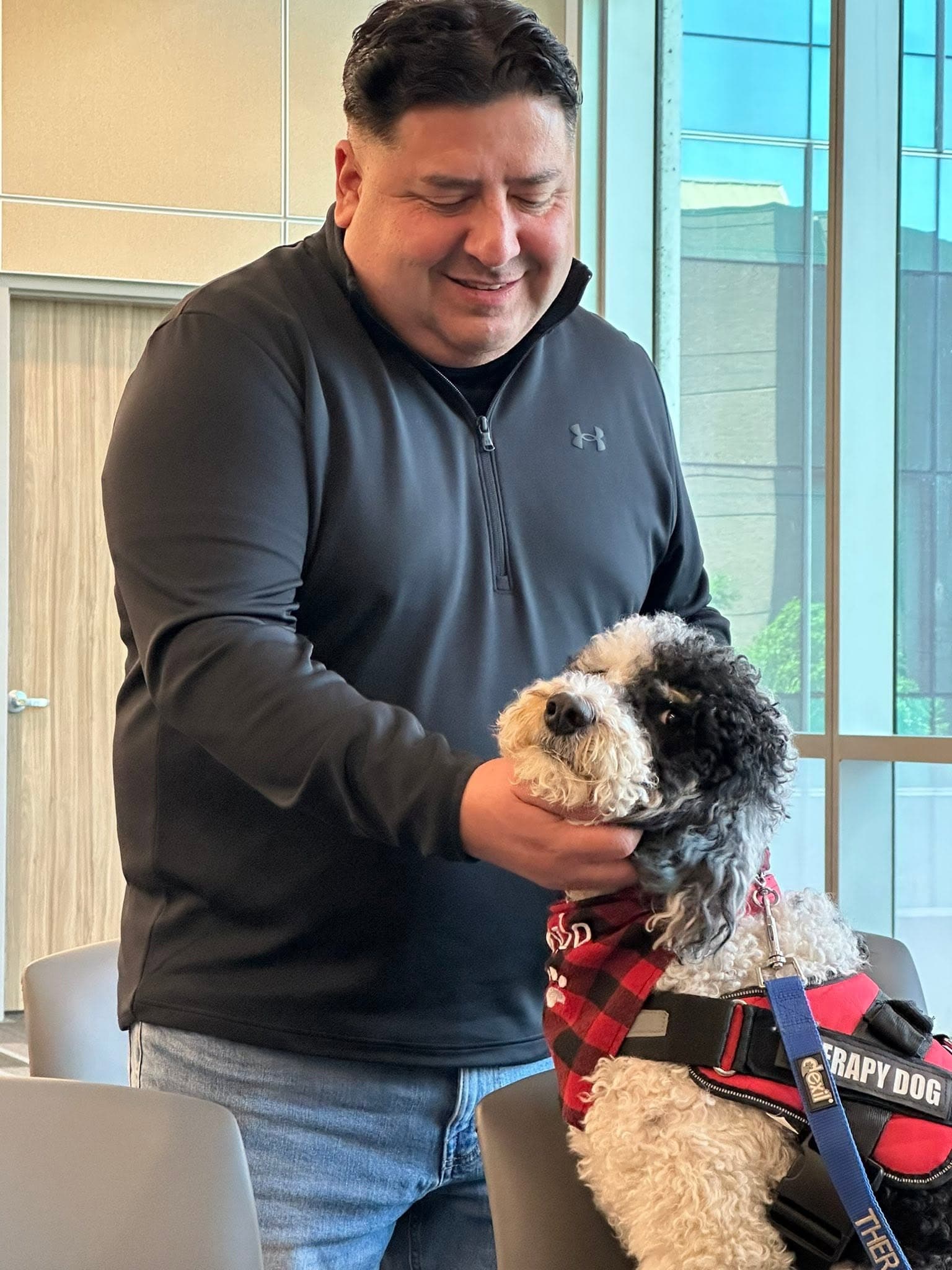 Therapy dog greeting a man during a community visit